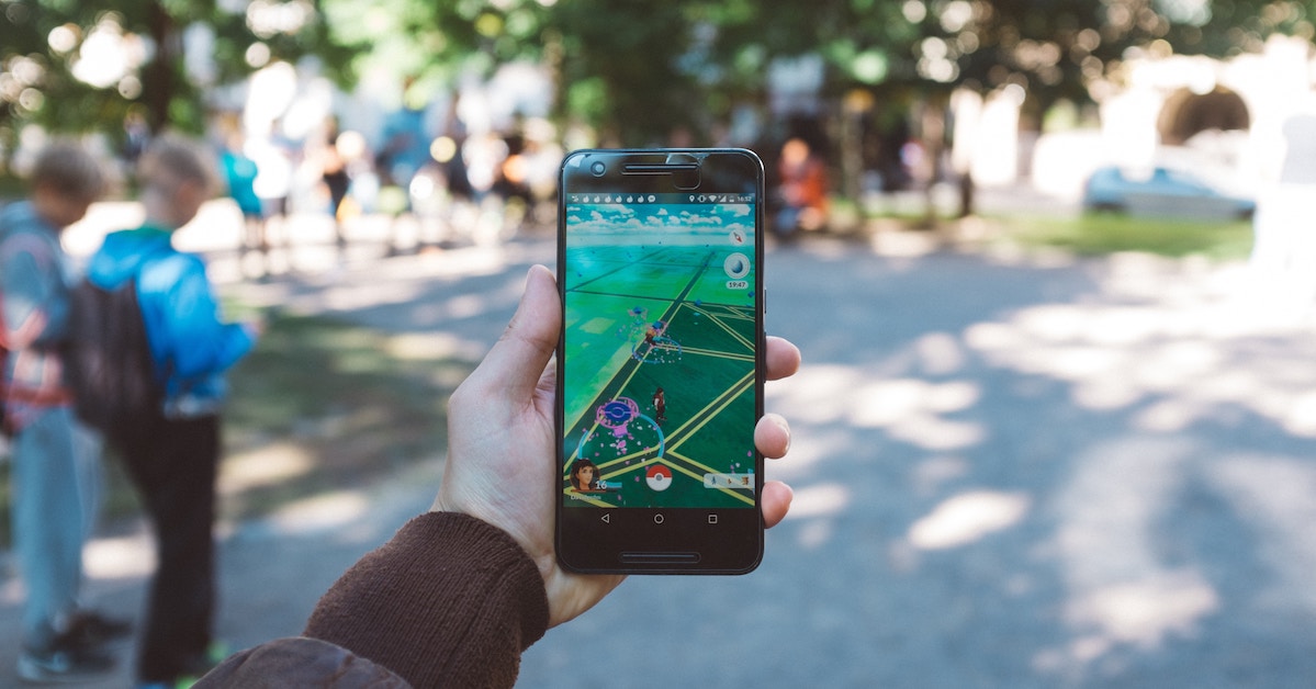 Pessoa segurando um celular com o jogo Pokémon Go aberto - realidade aumentada como funciona