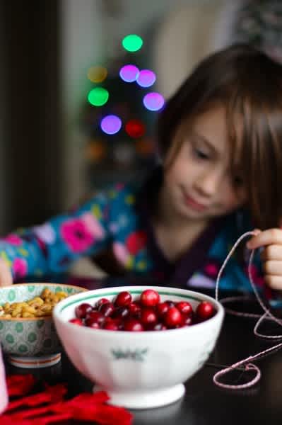 stringing-red-cranberries-for-a-garland-399x600
