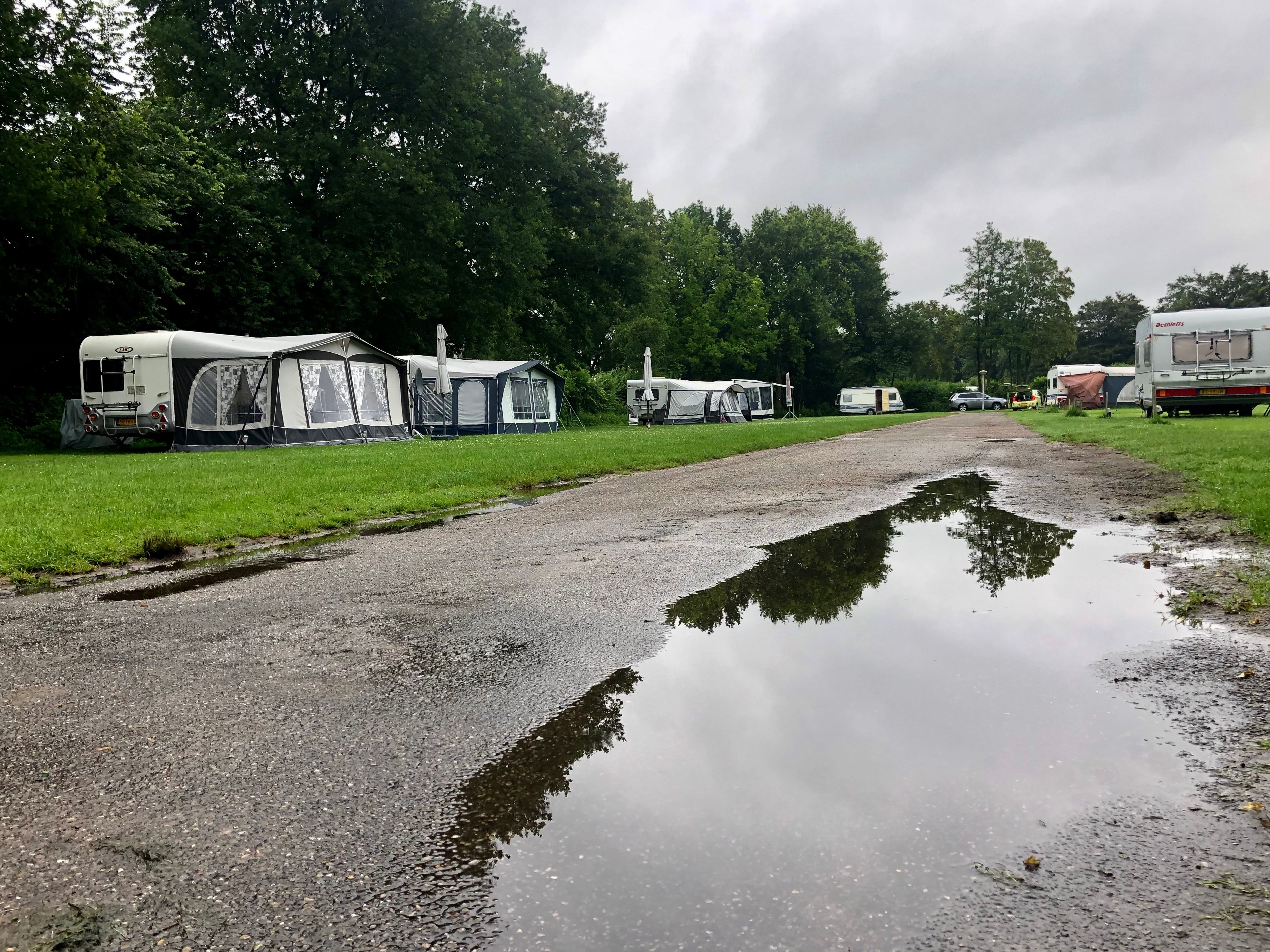 Plassen water door regen op verlaten camping in de zomer