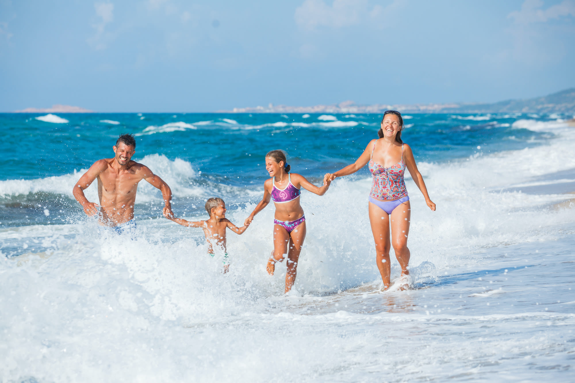 Familie met twee kinderen heeft plezier in de golven van de Middellandse Zee