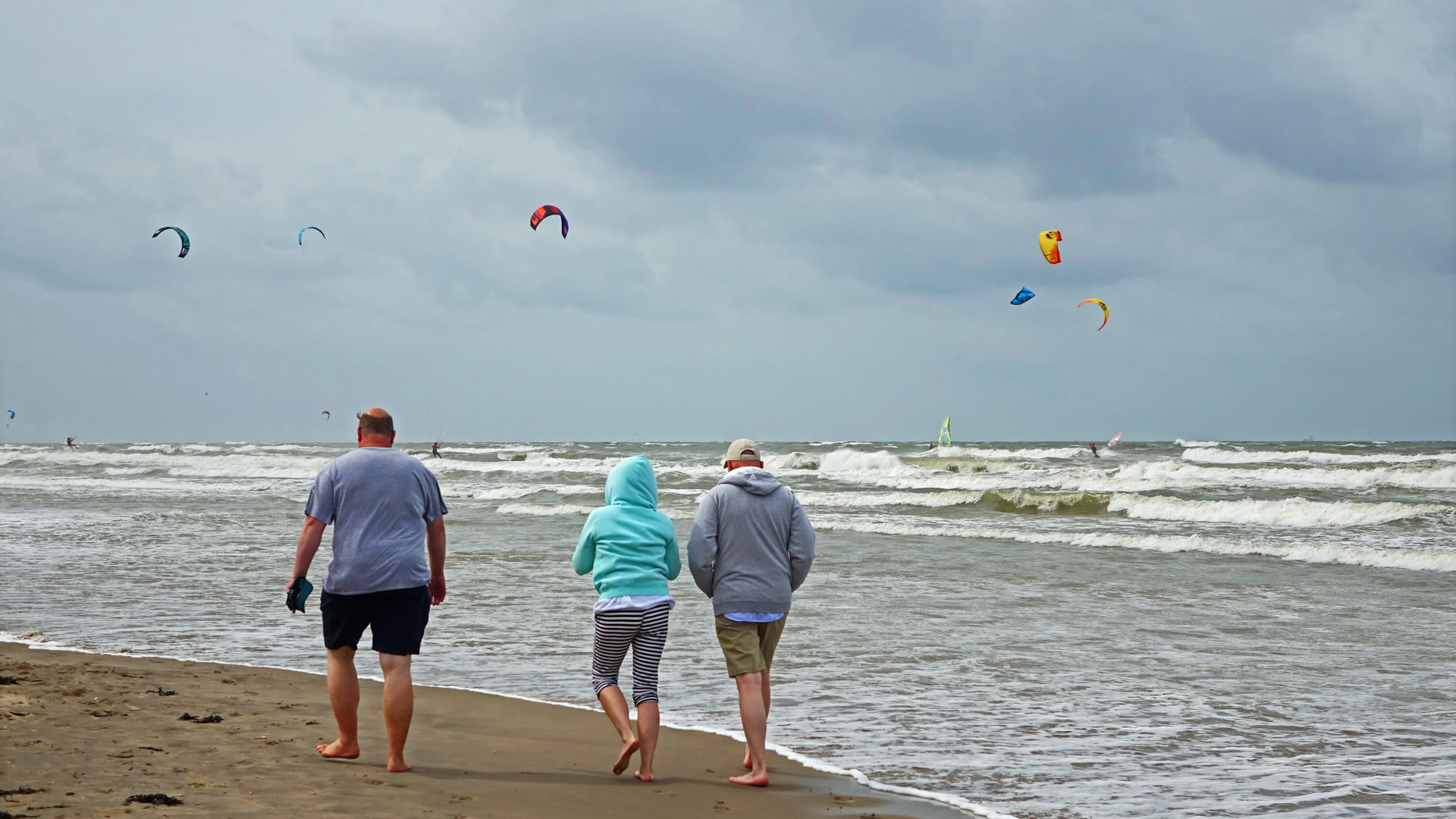Wandelaars aan het strand tijdens een koele dag in de zomer met vrij veel bewolking