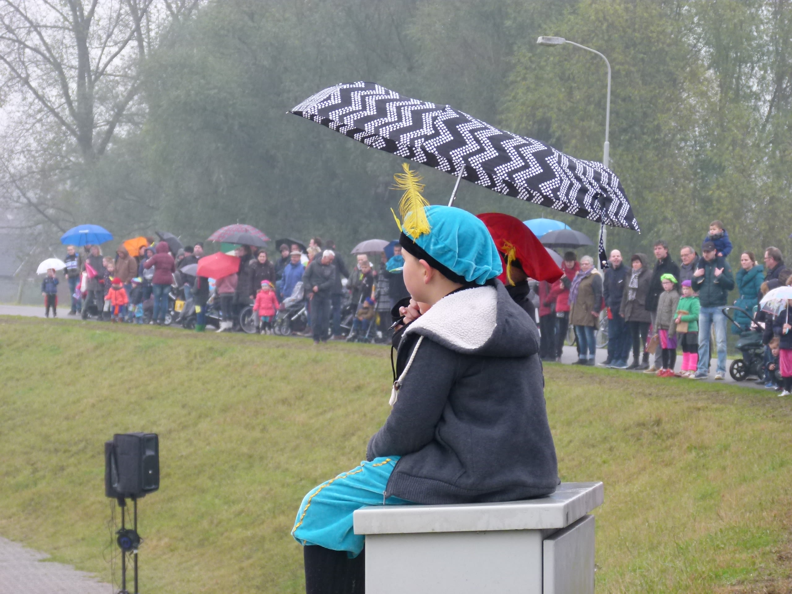 Kindjes wachten in de regen met paraplu op intocht Sinterklaas. Foto: Loes van Eck-Verhoeven