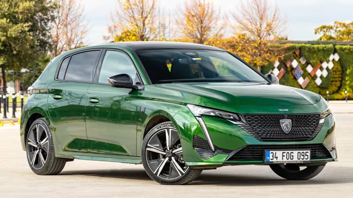 Zielony hatchback Peugeot 308 zaparkowany na zewnątrz. Zielony hatchback Peugeot 308 zaparkowany na zewnątrz.