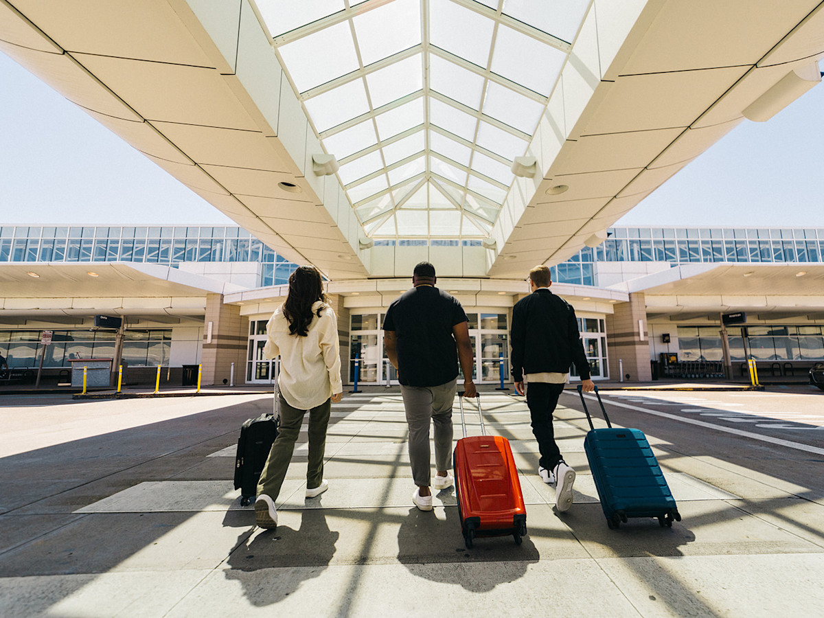 A photo of passengers walking across the crosswalk and into the Terminal of CVG Airport.