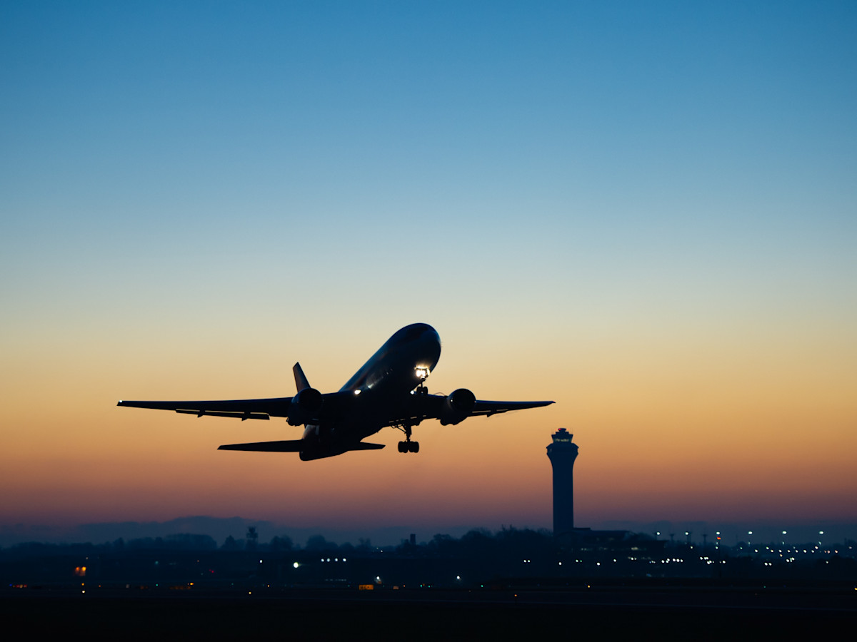 A photo of a plane taking off at sunset.