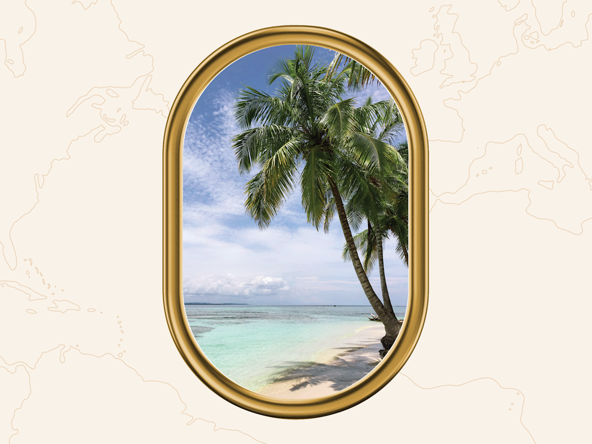 A photo of a beach setting seen outside a golden airplane window.