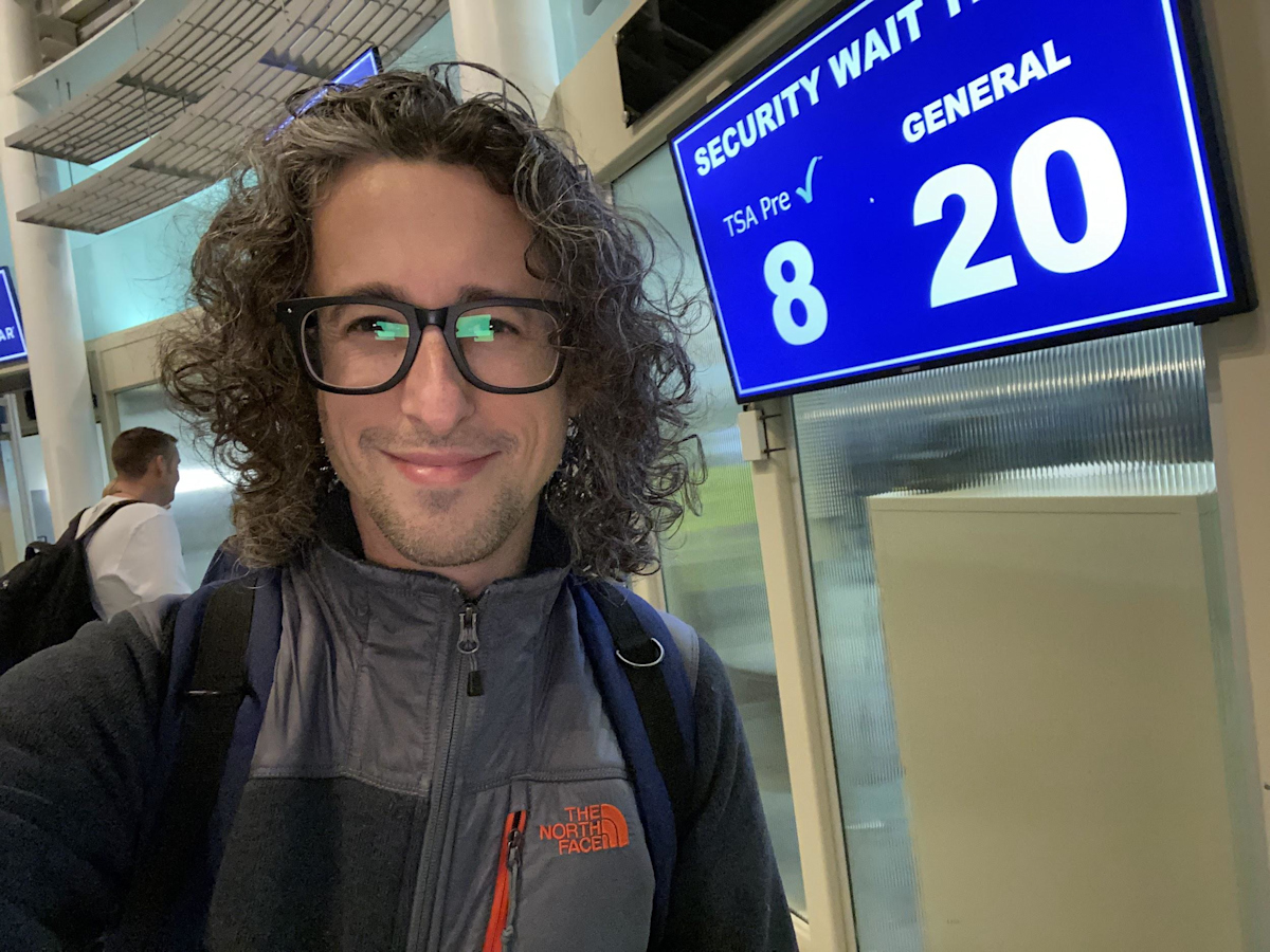 Jay Kruz in Front of CVG Security Wait Times Board