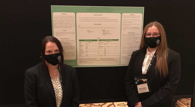 Students studying Criminal Justice at Lake Erie College in Painesville Ohio posing in front of their presentation at a conference. 
