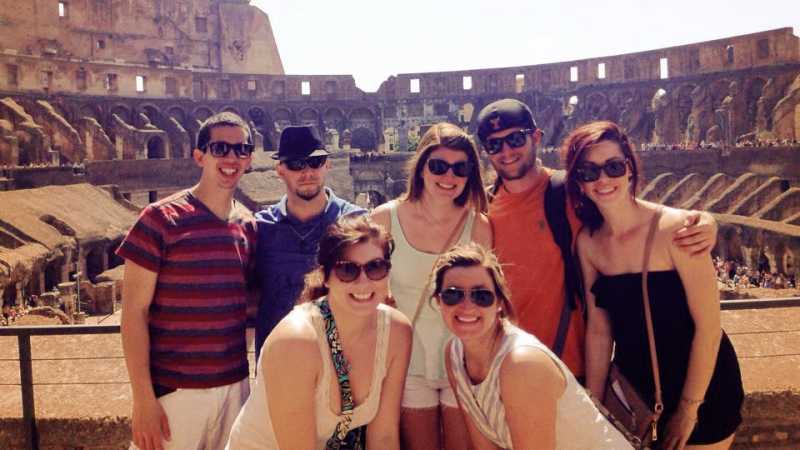 Several students posing in front of the Colosseum in Rome, Italy.