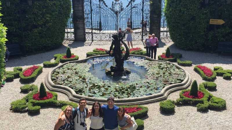 学生们在意大利伦巴第科莫湖畔的卡洛塔别墅的喷泉和花园前摆姿势.