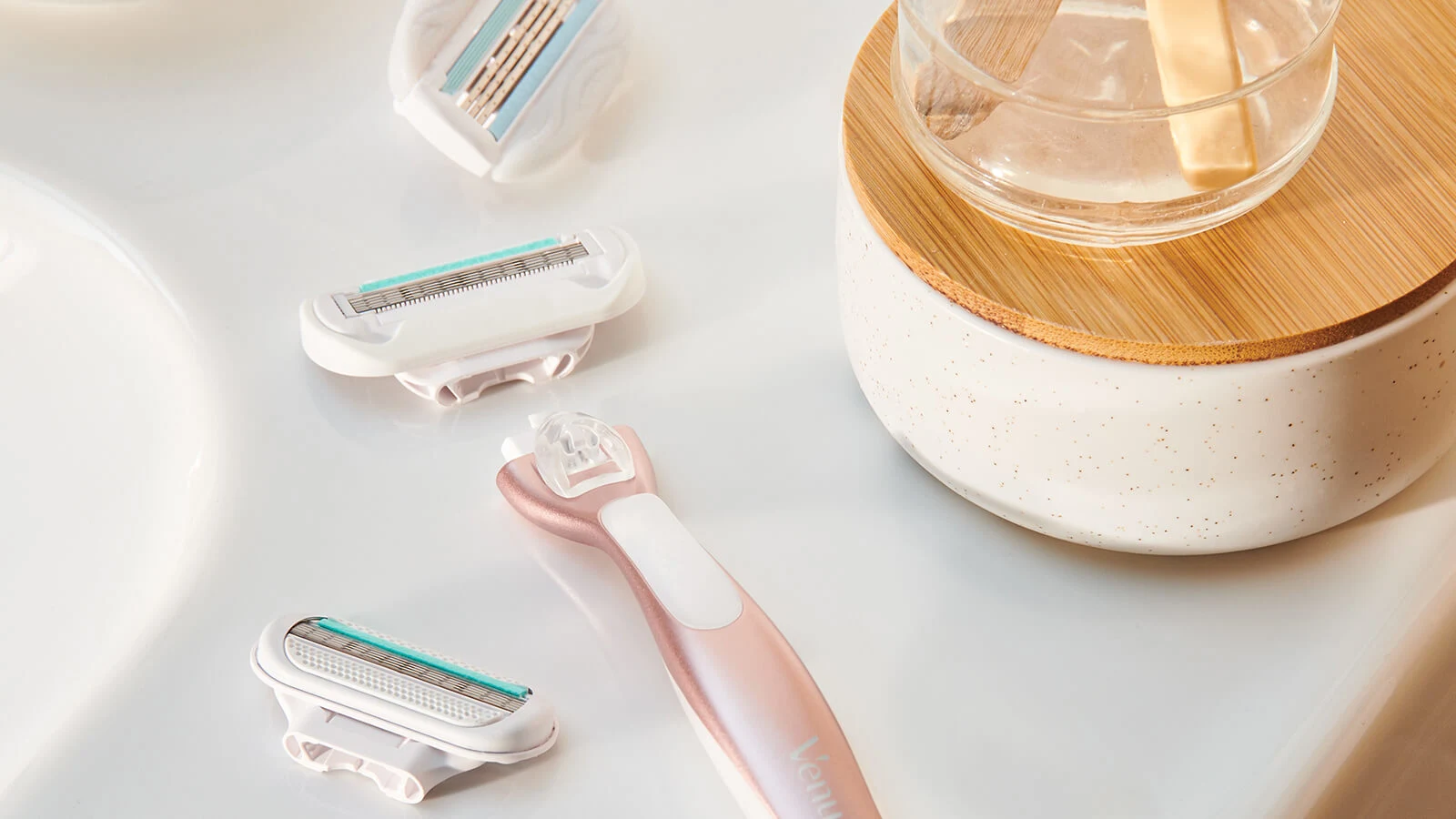 Deluxe Smooth Sensitive Rosegold razor with refills placed on the bathroom sink