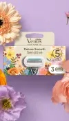 A package of Venus Deluxe Smooth Sensitive + Rifle Paper Co. Razor Blades surrounded by flowers, with a purlpe background