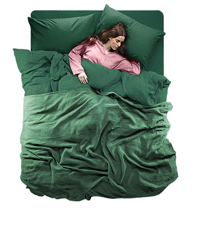 Top down view of a woman in pink pyjamas laying in a green Silentnight Eco Comfort Bed