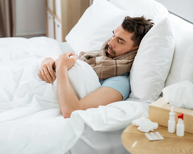 Man sleeping in bed, propped up with pillows