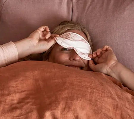 Woman beating insomnia with an eye mask