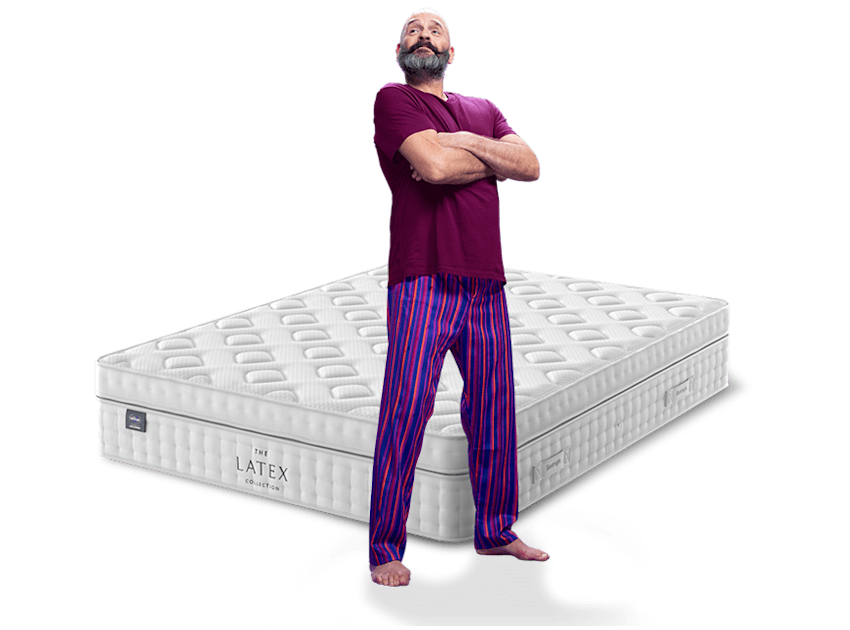 man in purple pyjamas with mattress behind