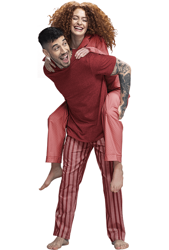 A young couple - man holding woman in Pyjamas