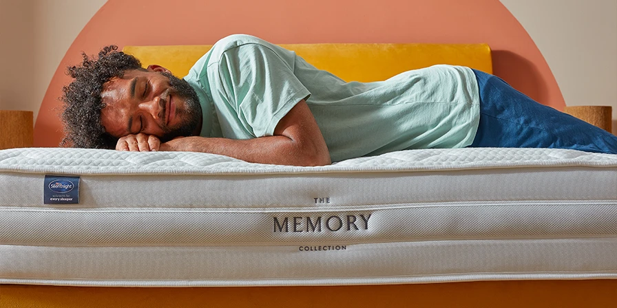 man laying across memory foam mattress