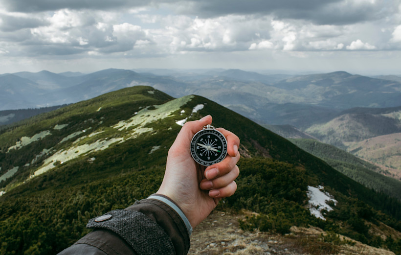 Person using a compass in the wilderness