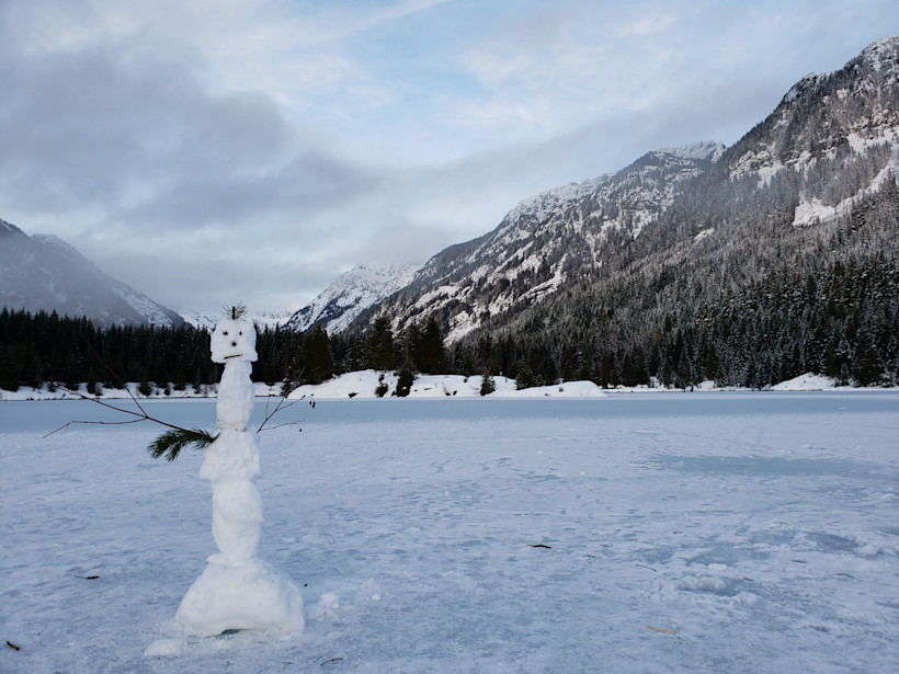 Snowman on frozen Gold Creek Pond. Gold creek pond snowshoe hike.
