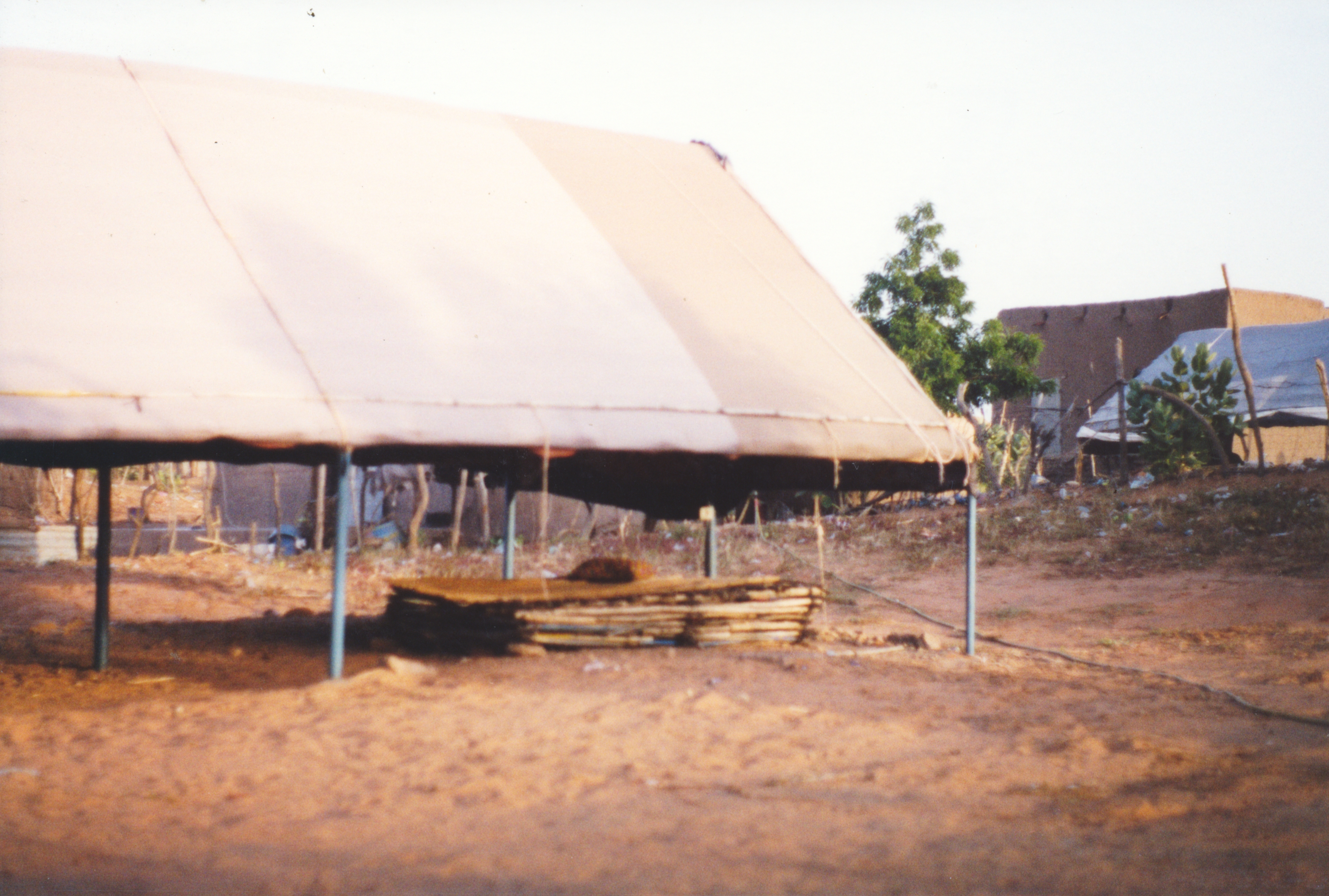 A hangar, or semipermanent tent, with a wooden sleeping platform underneath.