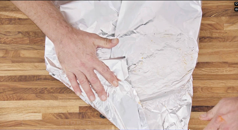 Aaron Franklin wrapping ribs with tinfoil step 3