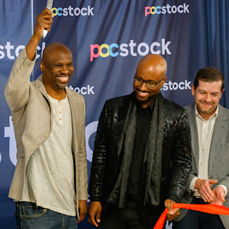 Three guys stand joyously having cut the ribbon to open their business, the name of which, pocstock, is on a blue background behind them.