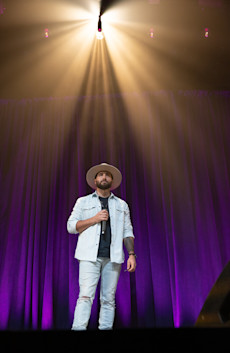 Winner Mitch Clark on stage holding the mic