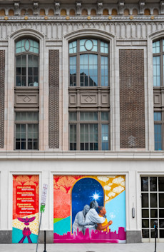 a mural on a school building with persony windows