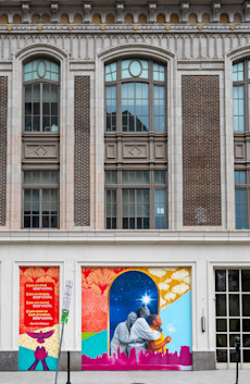 a mural on a school building with persony windows
