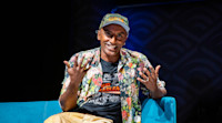Chef Marcus Samuelsson on stage at Audible wearing an "Our Harlem" t-shirt.