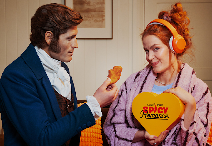 A photo of Maddy MacRae being offered a drumstick by a Regency-era dressed man.
