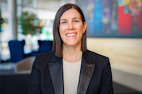 A headshot of Robyn Brown. She has dark, mid-length hair and is wearing a black blazer with a white shirt.