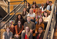 A group photo of Audible's Editors sitting on a stairwell, smiling.