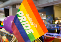 A rainbow flag with the words Audible Pride written across it sits front and center in the picture. It is decorating Audible's cafeteria at out headquarters in Newark.