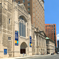 A close up of the front of the Audible Innovation Cathedral in downtown Newark with the street beyond it.