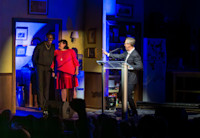 Audible CEO Bob Carrigan at podium facing actor Colman Domingo and Head of Audible Theater Kate Navin on stage. 