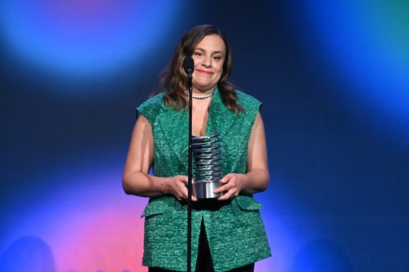 a woman holding a silver award