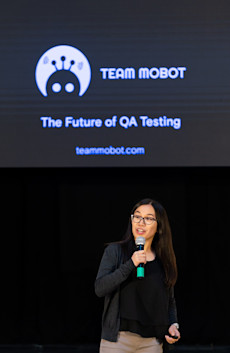 The founder of Team Mobot, a tech start-up, presenting her company with the logo on a screen behind her.