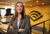 A headshot of Bennett Chiles. She's wearing a blazer and has shoulder-length hair. The Audible logo is visible on a wall behind her.