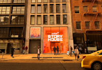 A rendering of the exterior of Audible Story House. The interior is partially visible behind a large, orange window.