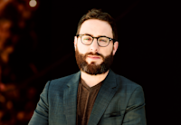 a person with a beard wearing glasses