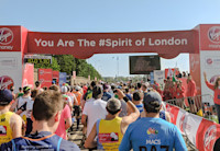 A crowd of runners going through the starting gate at the Virgin Money London Marathon