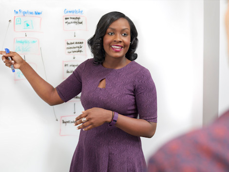Isa Watson, the founder of a tech startup, presenting a flowchart on a whiteboard.