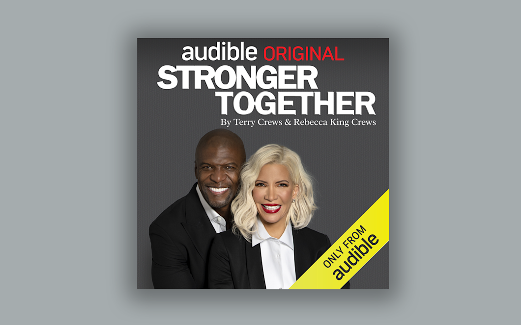 Set on a grey background, the cover art of "Stronger Together" showcases the authors Terry Crews and Rebecca King-Crews both in a black suit jackets and white shirts. The title "Stronger Together" is in large white text above their heads.