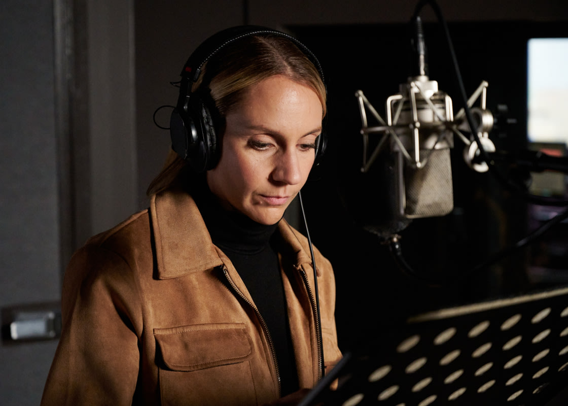Léane Labrèche-Dor stands in a recording studio narrating an audiobook.