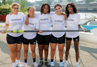 a group of teens posing for a picture, holding a paddle
