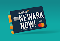 The Audible Bucks Visa card with the words "Newark Now!" is displayed on a teal blue background.