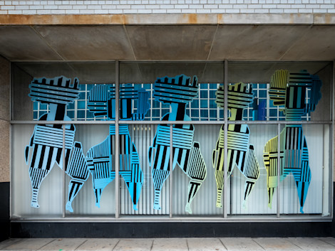 a storefront with persony colorful striped figures
