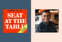 The cover for "Seat at the Table" which is red and white is on a blue background, next to a headshot of Chef Marcus Samuelsson. 